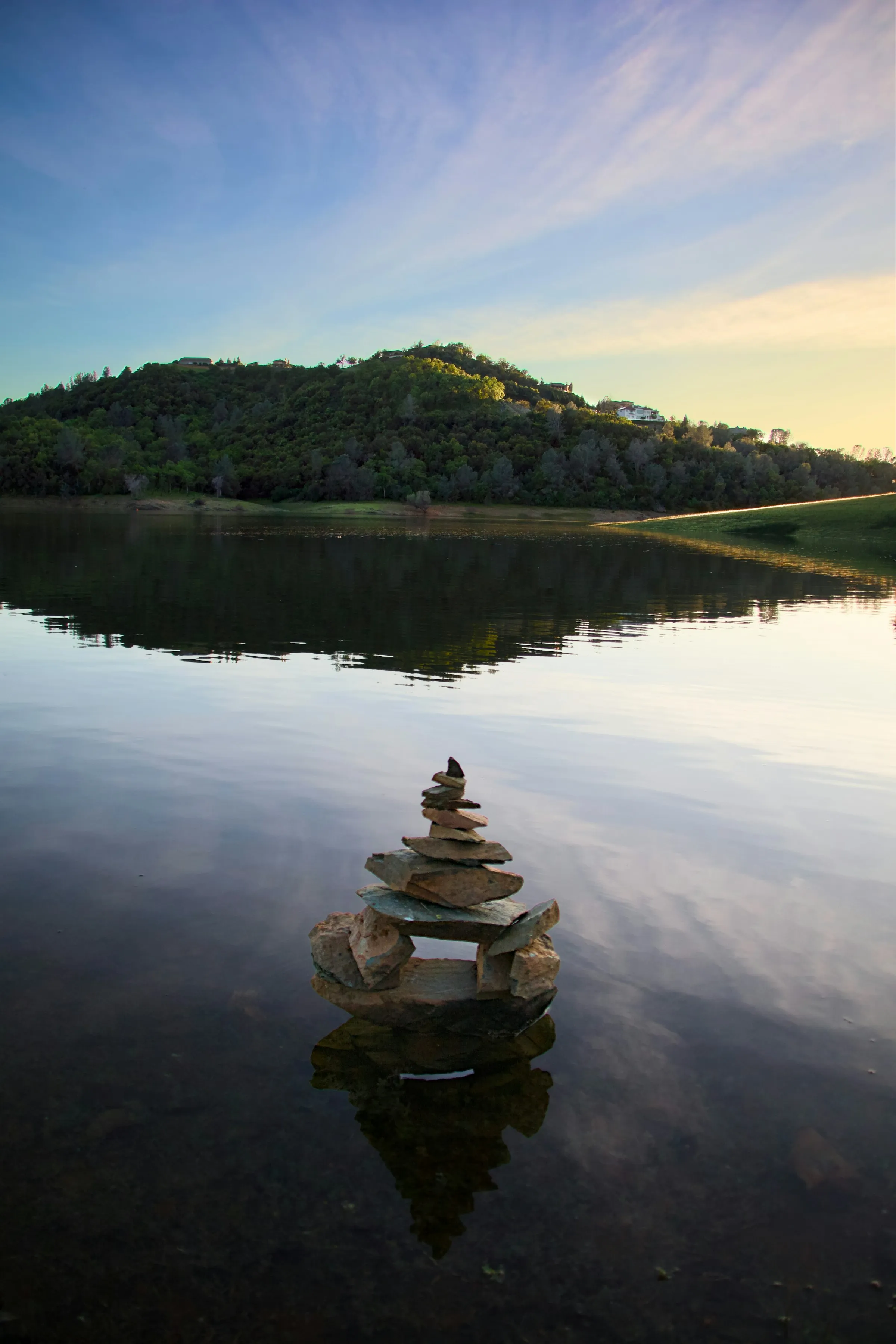 Balanced stones in still water at sunrise