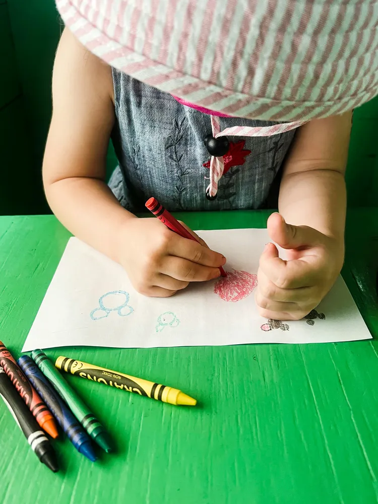 Child drawing with crayons